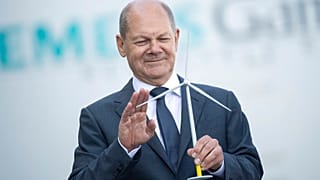 Olaf Scholz német kancellár egy szélturbina modelljével 2022. augusztus 25-én