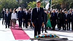 French President Emmanuel Macron pays his respect after laying a floral wreath at the Martyrs Monument in Algiers on August 25, 2022.