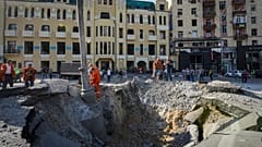 A view of a crater from a night Russian rocket attack, near to damaged buildings in downtown Kharkiv, Ukraine, Saturday, Aug. 27, 2022.