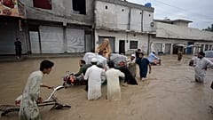 Des Pakistanais emportent leurs maigres biens