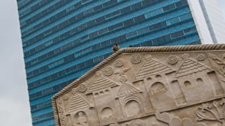 A sparrow sits on top of a traditional Bosnian monument, stećak, in front of the state-level government building in Sarajevo, 23 August 2022