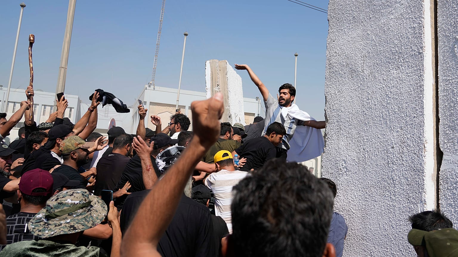 Simpatizantes del clérigo chií Muqtada al-Sadr intentan derribar las barreras de hormigón en el área de la Zona Verde de Bagdad, dónde se encuentra la sede del Gobierno.