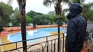 An employee looks at the deserted swimming pool in the closed campsite 'Les Galets' in Argeles-sur-Mer, 21 April 2020