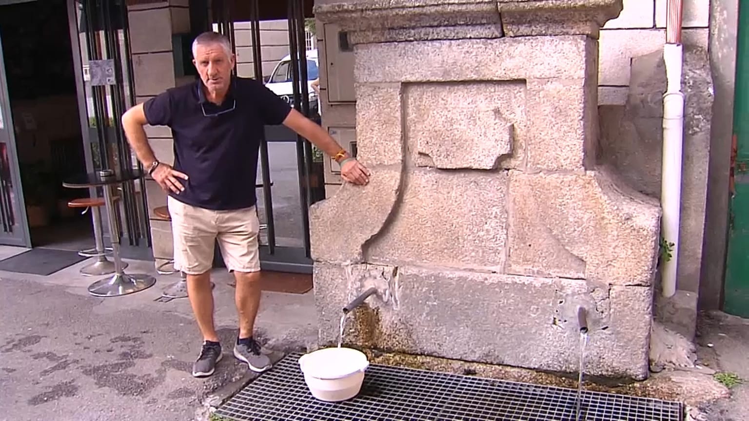 Un hombre llena un cubo en una fuente de Ribadavia, Orense, ante la falta de suministro en el arroyo de captación