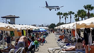 طائرة تابعة للخطوط الجوية القطرية من طراز إيرباص A320 تحلق فوق أحد الشواطئ مع اقترابها من الهبوط في مطار لارنكا الدولي في جنوب قبرص في 28 أغسطس 2022.