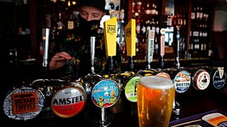 A barman draughts beer in the Black Lion pub in Hammersmith in London