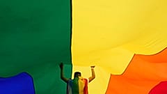 A participant holds up a large rainbow flag during the annual LGBT pride march in Belgrade, 18 September 2021