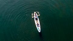 A man paddles on a surf board 
