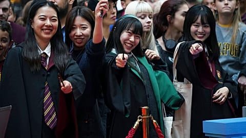 Harry Potter fans pose for a photo at the Back to Hogwarts event, at King's Cross station in London, Thursday, Sept. 1, 2022