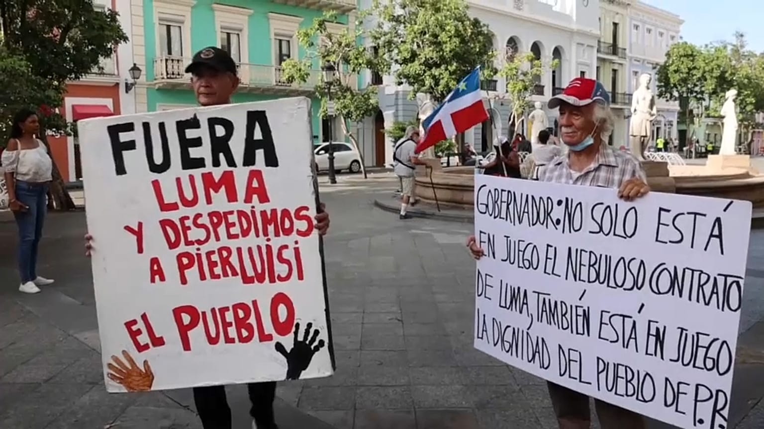 Dos manifestantes con pancartas en las protestas de este jueves en Puerto Rico