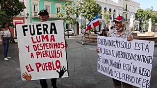 Dos manifestantes con pancartas en las protestas de este jueves en Puerto Rico