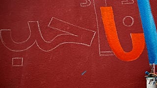 فنان فلسطيني يرسم جدارية مكتوب عليها "أنا أحب" على مدرسة تديرها وكالة الأمم المتحدة لإغاثة وتشغيل اللاجئين الفلسطينيين (أونروا) في غزة. 2016/05/10