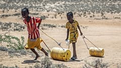 Des jeunes filles tirent des récipients d'eau d'un puits pour rentrer dans leurs huttes dans le village de Lomoputh, dans le nord du Kenya, 12 mai 2022.