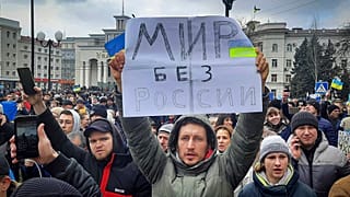 Un homme brandit un message sur lequel est écrit un "monde sans Russie", lors d'un rassemblement contre l'occupation russe à Kherson, en Ukraine, le 5 mars 2022.