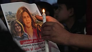 A Palestinian holds a picture of Shireen Abu Akleh during a candlelit vigil in Gaza.