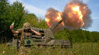 A Ukrainian soldier takes a selfie as an artillery system fires in the front line in Donetsk region, eastern Ukraine, Saturday, Sept. 3, 2022.