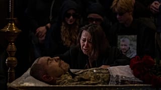 A relative cries next to the body of Viacheslav Nalyvaiko, a Ukrainian military officer killed during fighting against Russians, at his funeral in Kyiv 7 September 2022