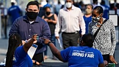 أشخاص يتلقون المعلومات أثناء حضورهم معرض الوظائف للتوظيف في 9 سبتمبر 2021 في إنغلوود ، كاليفورنيا