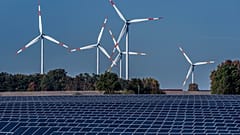 Windräder in Aktion - mit Solarpanelen im Vordergrund 