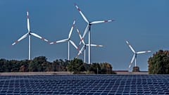 Wind turbines turn behind a solar farm in Rapshagen, Germany, Oct. 28, 2021.