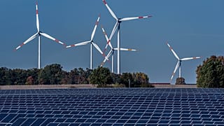 Windräder in Aktion - mit Solarpanelen im Vordergrund