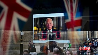 Des passants tentent d'apercevoir le discours télévisé du nouveau roi Charles III alors qu'ils passent devant un pub à Londres, vendredi 9 septembre 2022