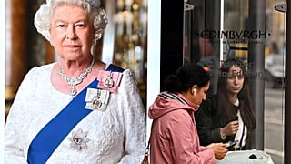 Pedestrians walk past an image of the late Queen Elizabeth II at bus stops in Edinburgh on September 9, 2022, a day after Queen Elizabeth II died at the age of 96.