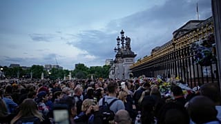Люди приходят к Букингемскому дворцу, чтобы отдать дань уважения почившей королеве