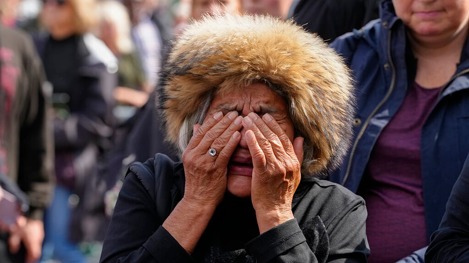 A mourner weeps as she pays respect to the Queen outside Buckingham Palace in London, Friday, Sept. 9, 2022.