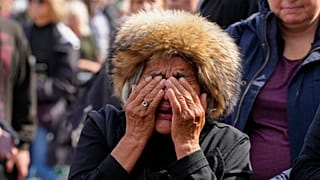 A mourner weeps as she pays respect to the Queen outside Buckingham Palace in London, Friday, Sept. 9, 2022.