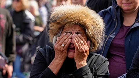 A mourner weeps as she pays respect to the Queen outside Buckingham Palace in London, Friday, Sept. 9, 2022.