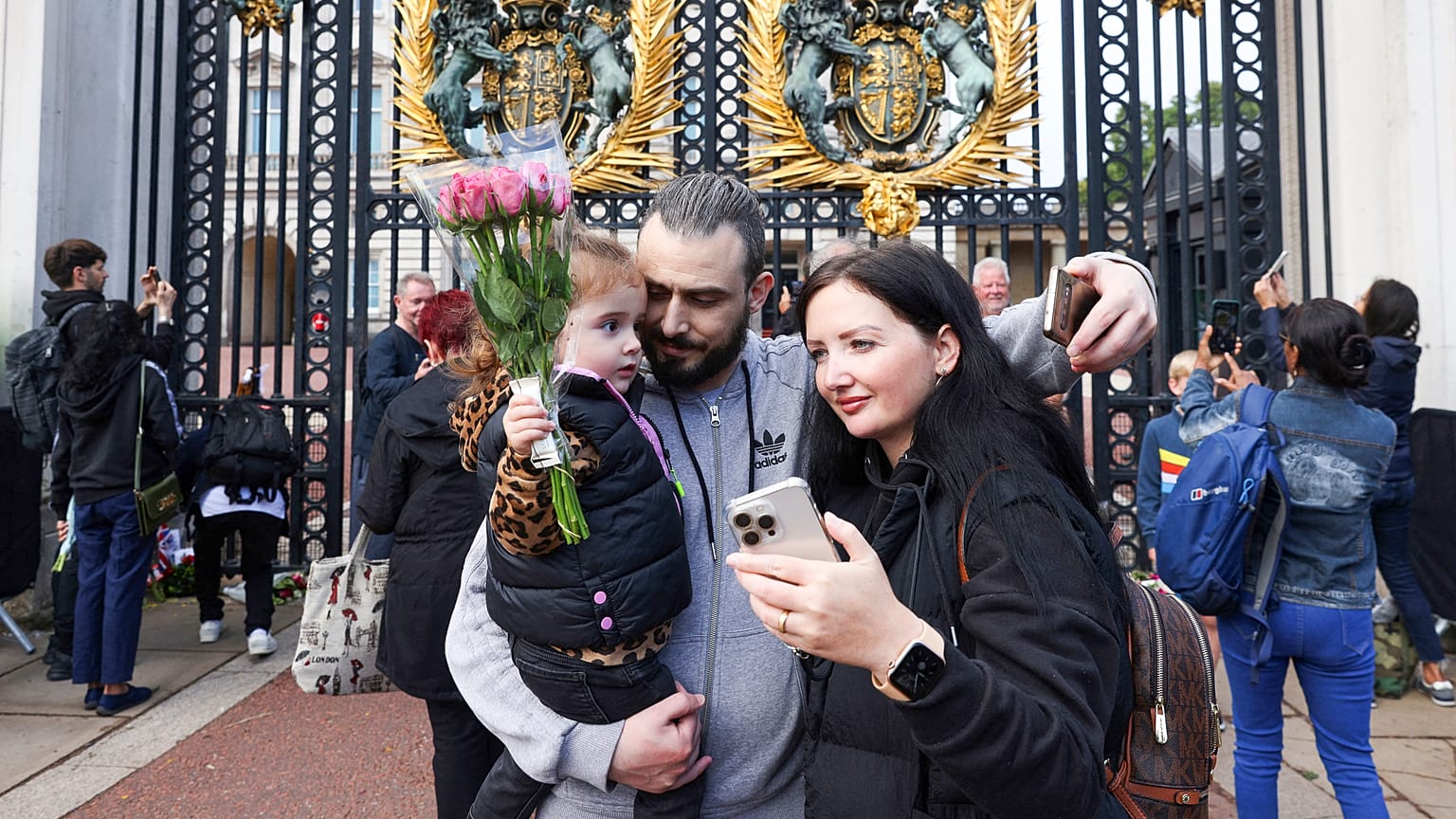 A family poses for a selfie photograph outside of Buckingham Palace in London, two days after Queen Elizabeth II died at the age of 96. September 10, 2022