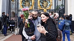A family poses for a selfie photograph outside of Buckingham Palace in London, two days after Queen Elizabeth II died at the age of 96. September 10, 2022