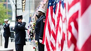 Firefighters salute each other outside the FDNY Engine 10, Ladder 10 fire station near the commemoration ceremony of the September 11, 2001 terror attacks. 