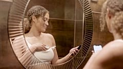 Image shows a woman using the Dotplot , a new device for women to perform at-home checks for breast cancer.