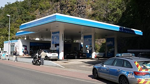 Media and a police car stand in front of a petrol station in Idar-Oberstein.