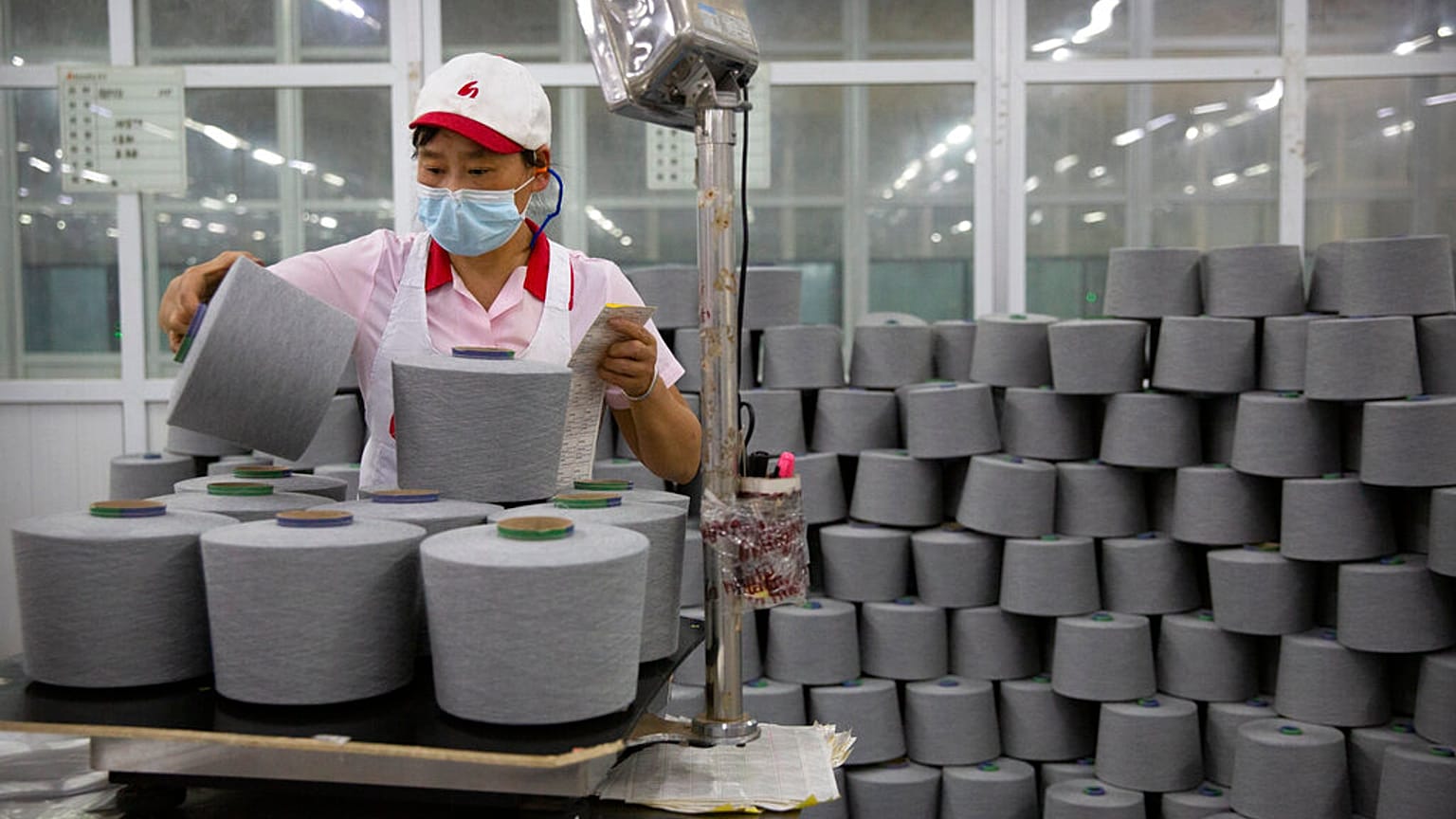 A worker packages spools of cotton yarn at a Huafu Fashion plant, as seen during a government organized trip for foreign journalists, in Aksu in China's Xinjiang Region.