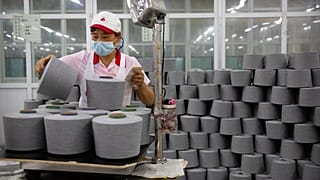 A worker packages spools of cotton yarn at a Huafu Fashion plant, as seen during a government organized trip for foreign journalists, in Aksu in China's Xinjiang Region.