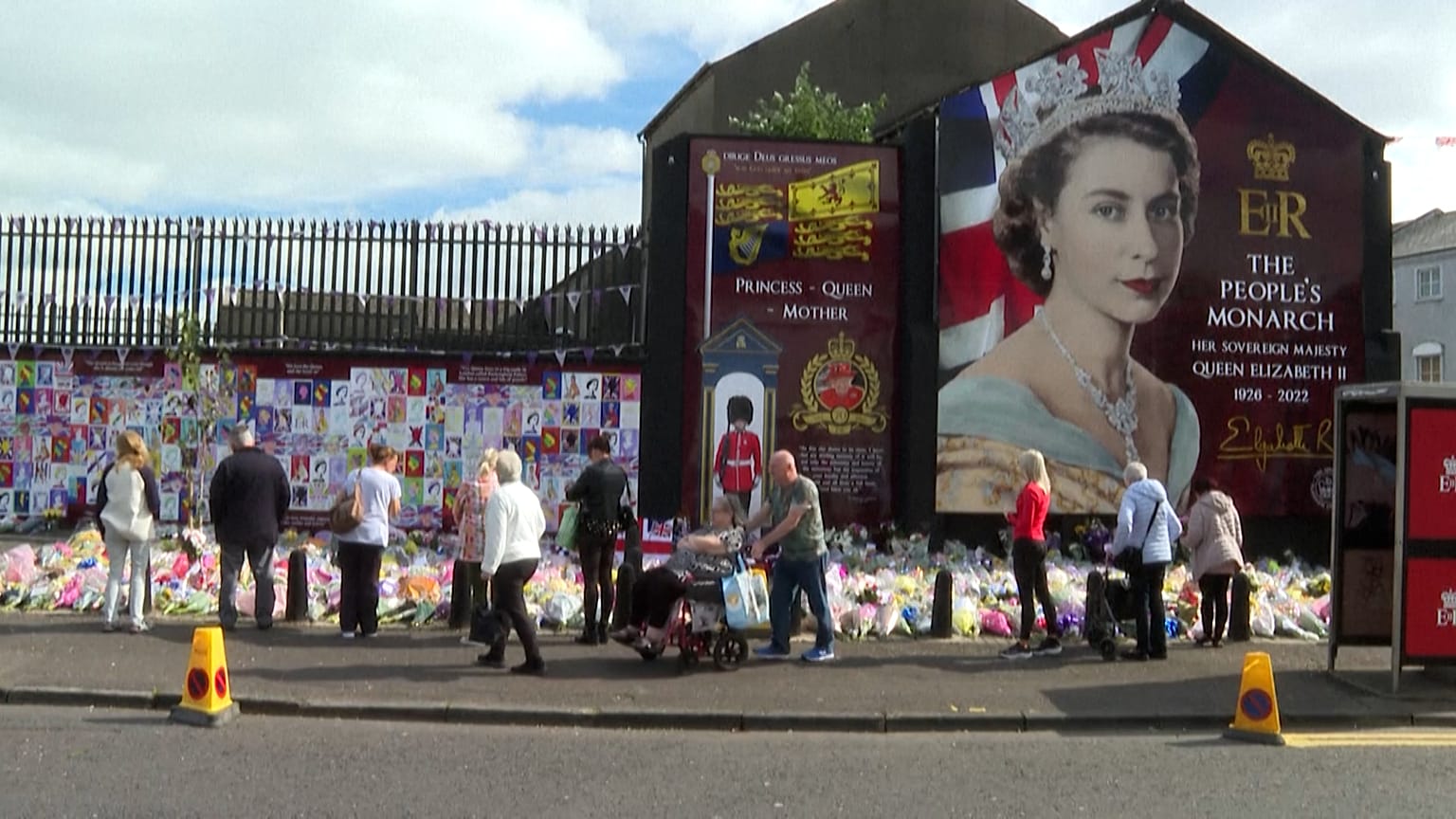 Des fleurs déposées devant un portrait d'Elizabeth II à Belfast (12/09/22)