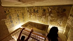 سياح ينظرون إلى قبر الفرعون المصري الشهير توت عنخ آمون، المعروض في علبة زجاجية بوادي الملوك. 2015/11/05