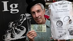 Учредитель Шнобелевской премии Марк Абрамс с купюрой в 10 трлн зимбабвийских долларов и "контейнером для хранения знаний"