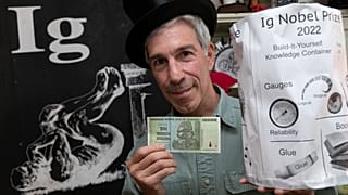 Учредитель Шнобелевской премии Марк Абрамс с купюрой в 10 трлн зимбабвийских долларов и "контейнером для хранения знаний"
