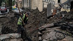 A man works next to a crater created by an explosion to fix the internet cables after a Russian attack in downtown, Kharkiv, Ukraine, Friday, 16 September 2022. 
