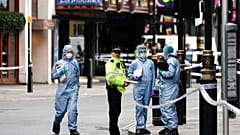 Des enquêteurs travaillant sur les lieux où les deux officiers de police ont été poignardés, à Londres, vendredi 16 septembre 2022.
