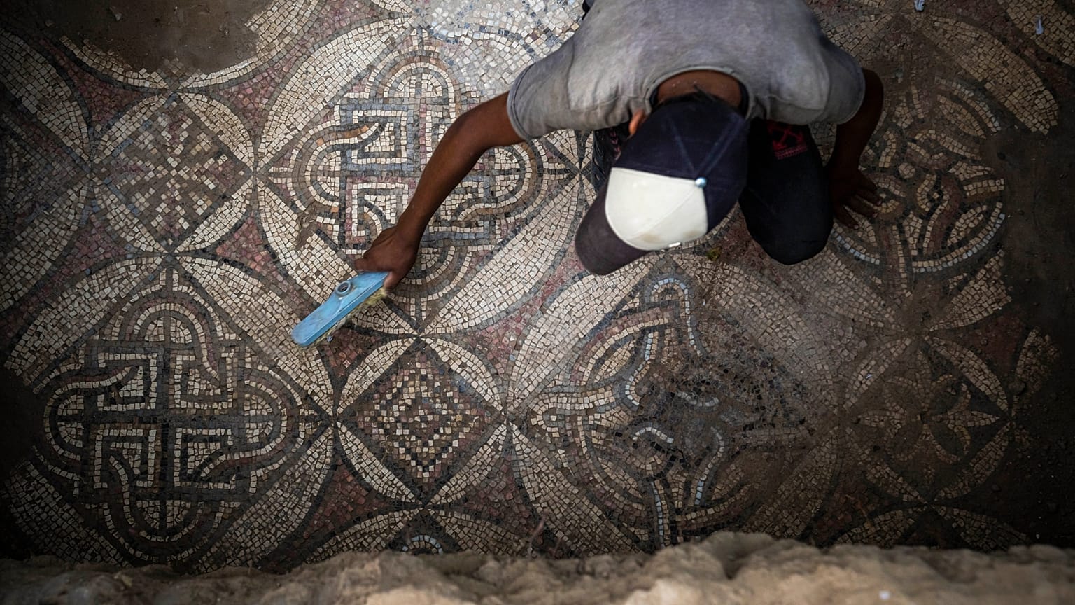 فلسطيني يزيل الغبار عن جزء من أرضية فسيفسائية في غزة تعود إلى العصر البيزنطي. 2022/09/05