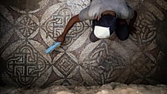 فلسطيني يزيل الغبار عن جزء من أرضية فسيفسائية في غزة تعود إلى العصر البيزنطي. 2022/09/05