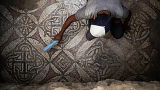 فلسطيني يزيل الغبار عن جزء من أرضية فسيفسائية في غزة تعود إلى العصر البيزنطي. 2022/09/05