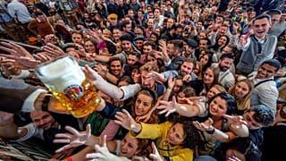 Cientos de jóvenes tienden la mano para conseguir cerveza gratis en una de las carpas de cerveza en la 187ª edición del Oktoberfest en Múnich, Alemania, el 17 de septiembre.