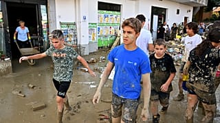 Дети идут по затопленной улице в городе Пианелло ди Остро, в провинции Анкона, Италия. 16 сентября 2022.