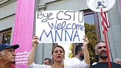 Διαδηλώτρια με πλακάτ που ζητά αποχώρηση από τον CSTO